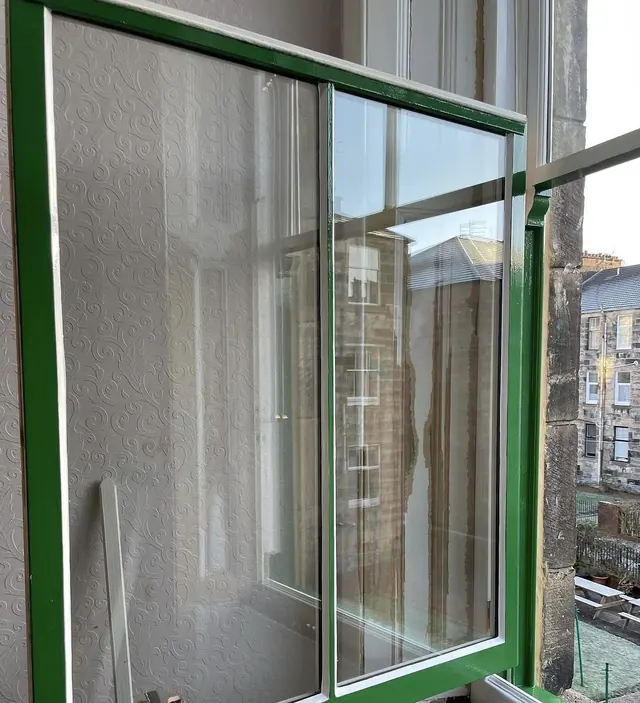 Sash window frame finished in bright green gloss