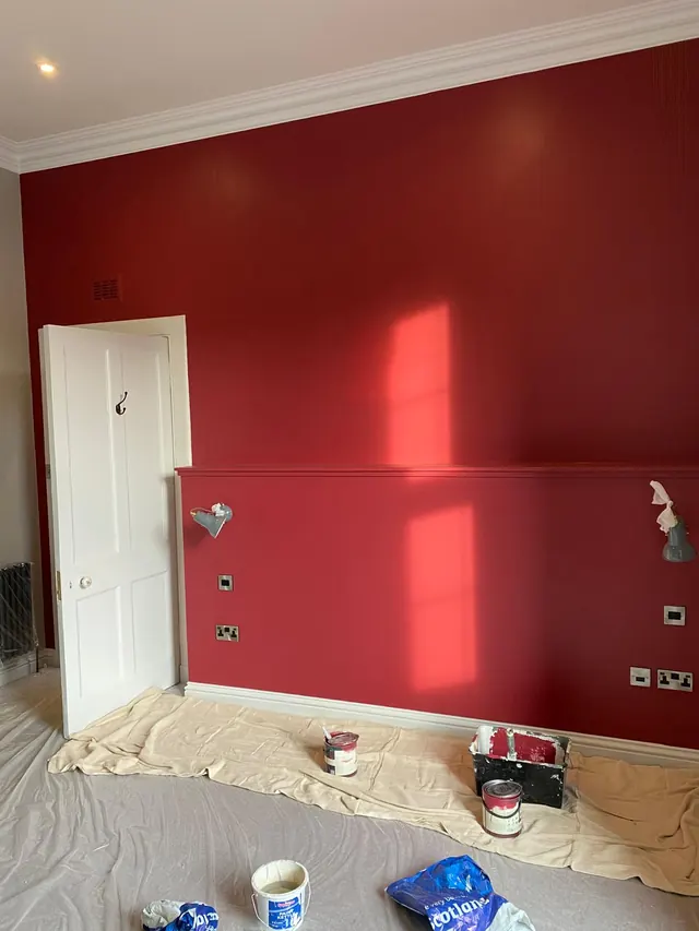 Deep red feature wall with white woodwork, mid-job