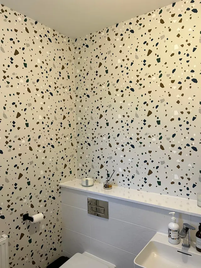 Terrazzo-pattern wallpaper hung in a cloakroom