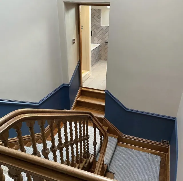 Stairwell with light walls and a deep blue dado rail